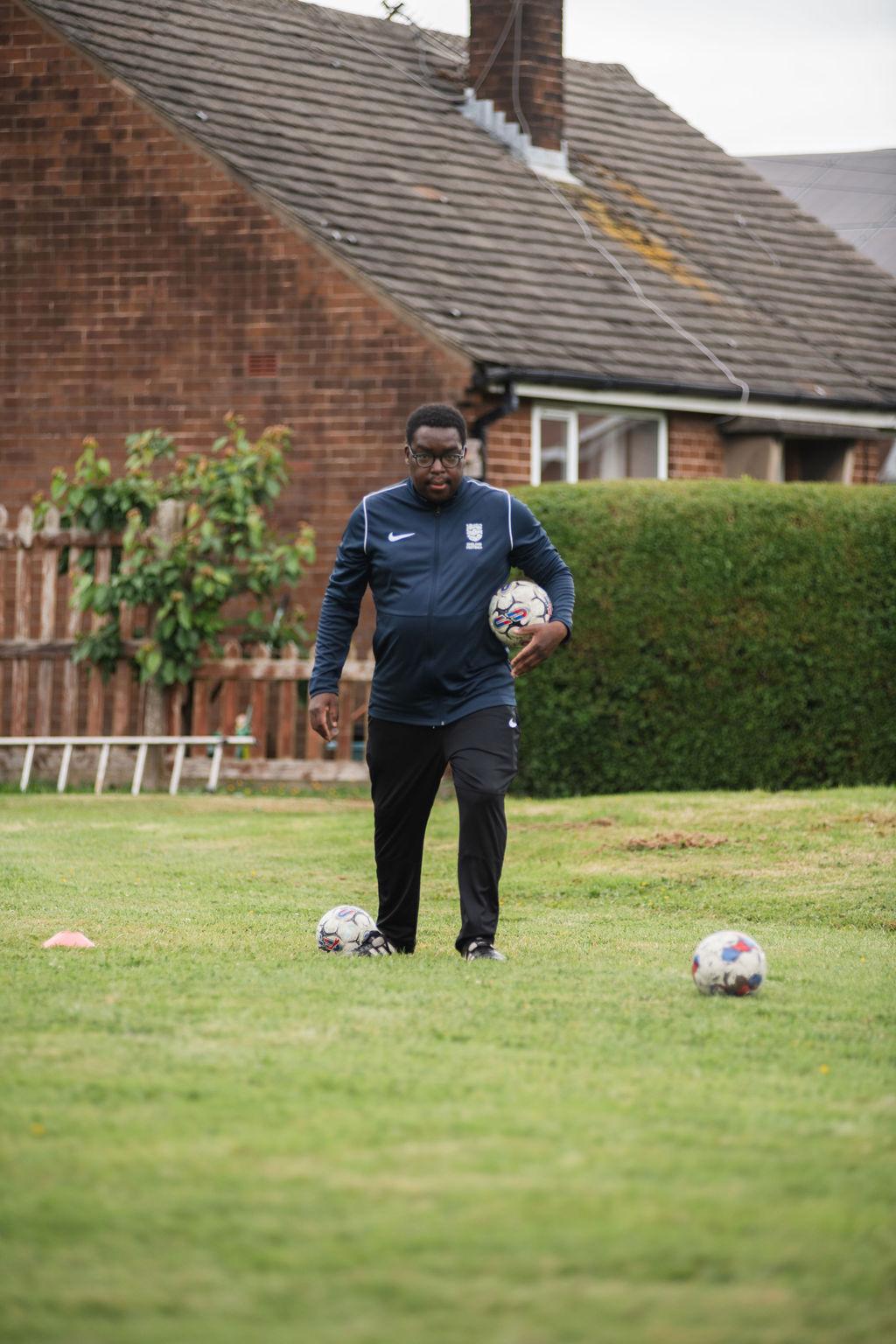 Coach Sagwati Malabi directing grassroots training session on grass field